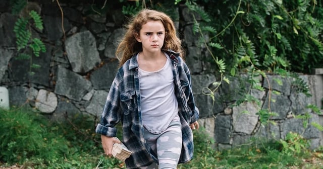 Lexy Kolker as Chloe Lewis bleeds out of her eye and holds a giant stack of cash in the movie Freaks.