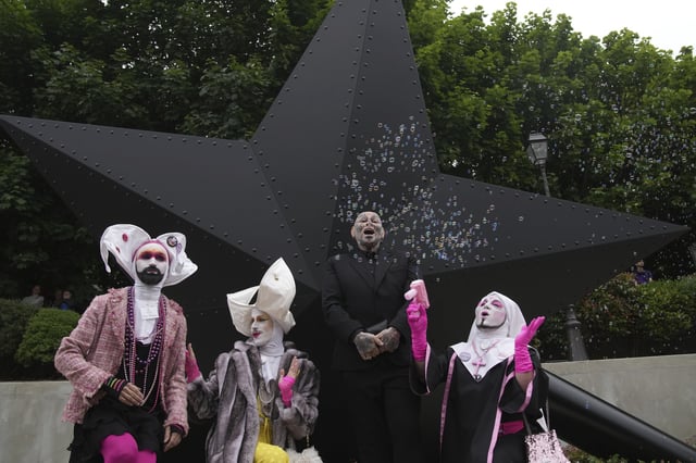 French artist Jean-Luc Verna, center, poses with performers during the inauguration of his sculpture, a memorial to the long-ignored gay victims of the Nazi regime and to all LGBTQ+ people persecuted throughout history, in Paris, Saturday, May 17, 2025. (AP Photo/Christophe Ena)