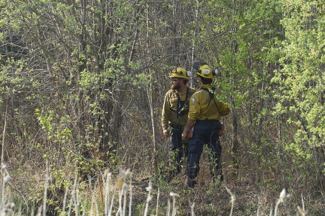 Members of the Manitoba Wildfire Program survey the land as fire crews continue to fight wildfires around Lac du Bonnet, Man., Thursday, May 15, 2025. THE CANADIAN PRESS/David Lipnowski