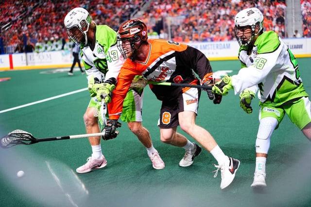 Saskatchewan Rush teammates Jake Boudreau (left) and Jake Naso (right) battle with Buffalo Bandits defender Dylan Robinson in Game 1 of the NLL finals. The Rush lost the match 12-10.