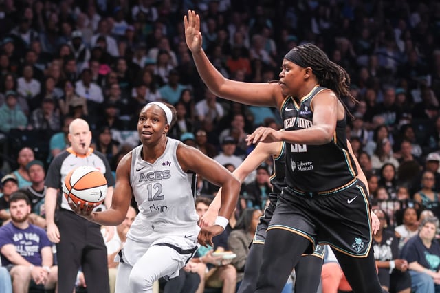 May 17, 2025; Brooklyn, New York, USA;  Las Vegas Aces guard Chelsea Gray (12) drives past New York Liberty center Jonquel Jones (35) in the first quarter at Barclays Center. Mandatory Credit: Wendell Cruz-Imagn Images