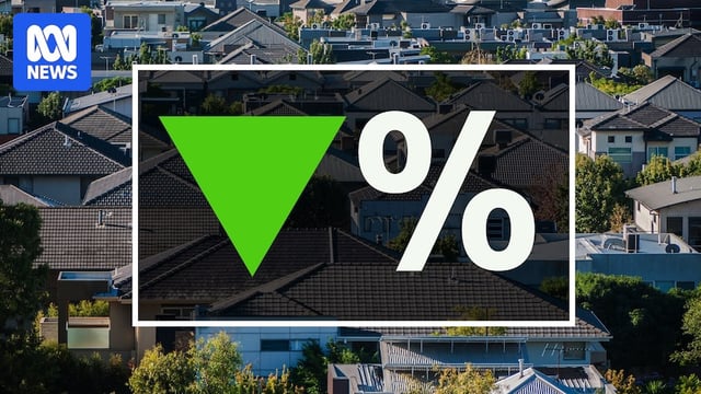 An aerial image of a housing development with a green arrow pointing downwards next to a percentage sign 