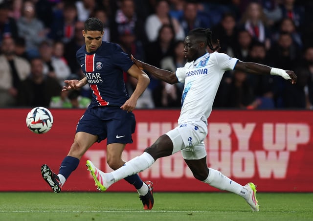 Soccer Football - Ligue 1 - Paris St Germain v Auxerre - Parc des Princes, Paris, France - May 17, 2025 Paris St Germain's Achraf Hakimi in action with Auxerre's Gideon Mensah REUTERS/Gonzalo Fuentes