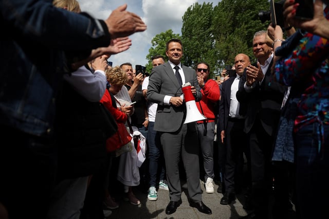 Civic Coalition presidential candidate, Warsaw Mayor Rafal Trzaskowski, holds a megaphone as he speaks to supporters during election meeting in Nowa Sol, Poland, May 14, 2025. REUTERS/Kacper Pempel/File Photo