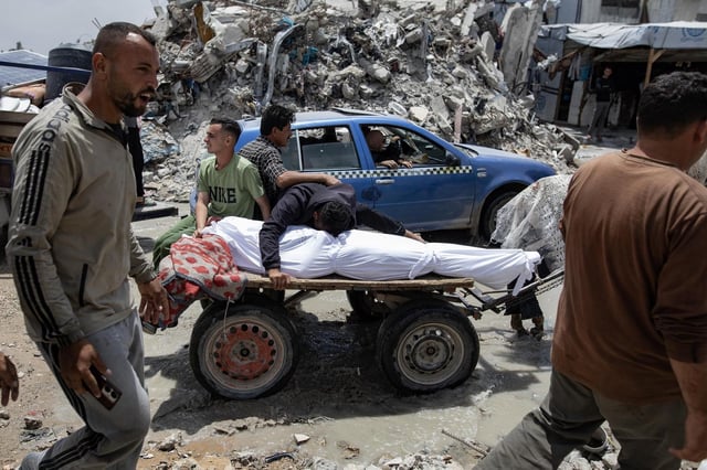 Palestinos junto a un fallecido por los ataques de Israel en la Franja de Gaza, esta semana.