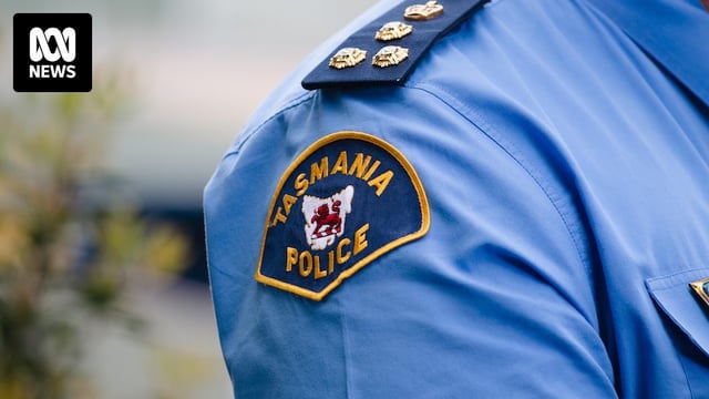 Blue and orange fabric badge on a blue shirt reads: Tasmania Police