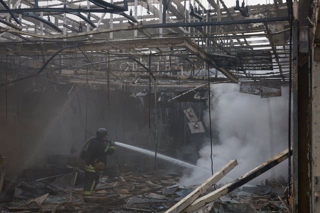 A firefighter works at the site of a Russian drone strike outside of Kyiv.