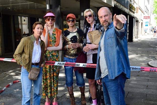 Eine Gruppe von Menschen steht an einem Polizeiabsperrband
