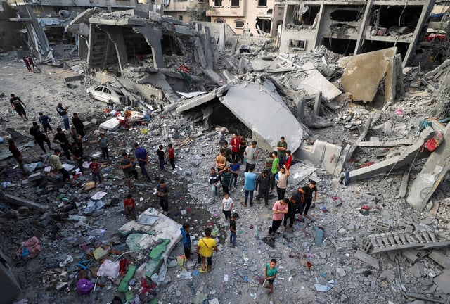 Palestinians inspect the site of an Israeli strike in Jabalya, northern Gaza on May 18, 2025.