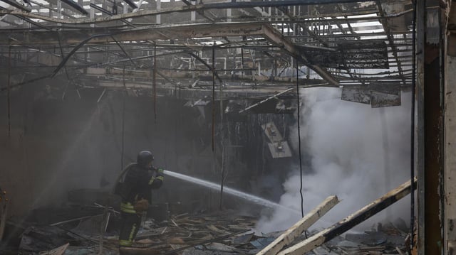 Ein Feuerwehrmann arbeitet in einem zerstörten Gebäude in der Nähe von Kiew nach einem Drohnenangriff.