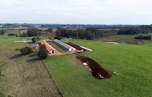 A drone view shows an excavator moving earth next to a hole in the ground at a poultry farm, after Brazil confirmed its first outbreak of bird flu on Friday, triggering protocols for a country-wide trade ban from top buyer China and state-wide restrictions for other major consumers, in Montenegro, Brazil May 17, 2025. REUTERS/Diego Vara
