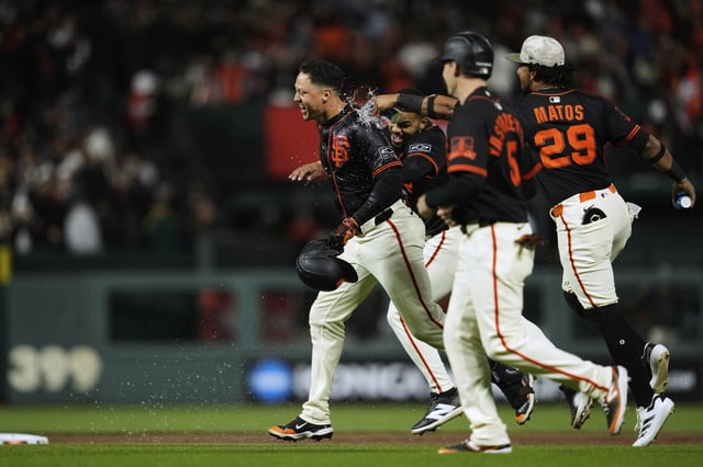 San Francisco Giants' Wilmer Flores, left, is doused with water by Luis Matos (29) after driving in the winning run against the Athletics on a walk with the bases loaded during the 10th inning of a baseball game Saturday, May 17, 2025, in San Francisco. (AP Photo/Godofredo A. Vásquez)