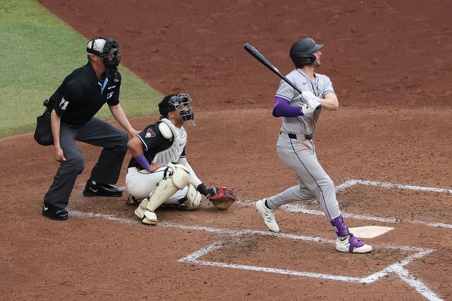 PHOENIX, ARIZONA - MAY 17: Ryan McMahon #24 of the Colorado Rockies hits a single against the Arizona Diamondbacks during the third inning of the MLB game at Chase Field on May 17, 2025 in Phoenix, Arizona.
