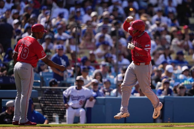 Los Angeles Angels’ Travis d’Arnaud, right, is congratulated by third base coach Bo Porter after hitting a solo home run during the eighth inning of a baseball game against the Los Angeles Dodgers, Sunday, May 18, 2025, in Los Angeles. (AP Photo/Mark J. Terrill)