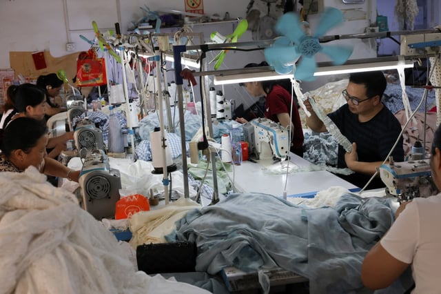 People work in a textile factory in Panyu district, Guangzhou, Guangdong province, China May 10, 2025. REUTERS/Go Nakamura/ File Photo