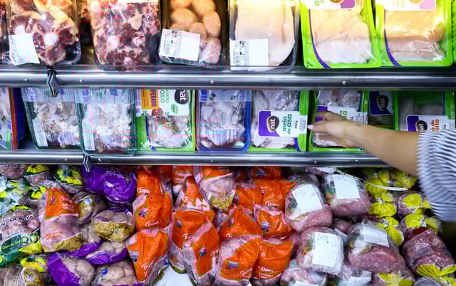 A consumer buys chicken at a local market, in Montenegro, Brazil May 17, 2025. REUTERS/Diego Vara/File Photo