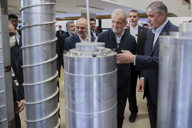 In this photo released by the Iranian Presidency Office, President Masoud Pezeshkian, second right, listens to head of Atomic Energy Organization of Iran Mohammad Eslami as he visits an exhibition of Iran&#39;s nuclear achievements, in Tehran, Iran, Wednesday, April 9, 2025.