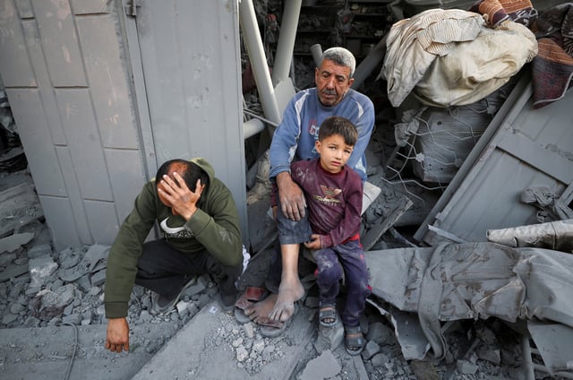 Des Palestiniens s’assoient près d’une site d’une frappe israélienne à Jabalia, dans le nord de la bande de Gaza, le 18 mai 2025.