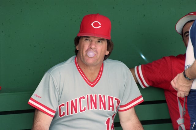 (Original Caption) 3/26/1989-Clearwater, FL- Reds&#39; manager Pete Rose blows a less than major league bubble as he looks out of the dugout prior to the Reds game against the Phillies. Rose is under investigation by the baseball commissioners office for alleged gambling.