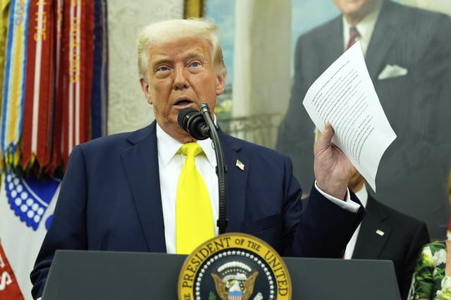 FILE - President Donald Trump holds a document with notes about Kilmar Abrego Garcia as he speaks with reporters in the Oval Office of the White House, April 18, 2025, in Washington.(AP Photo/Alex Brandon, File)