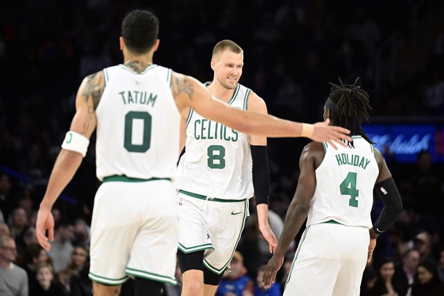 NEW YORK, NEW YORK - FEBRUARY 24: Kristaps Porzingis #8 of the Boston Celtics is congratulated by Jrue Holiday #4 and Jayson Tatum #0 after scoring a basket against the New York Knicks during the second half at Madison Square Garden on February 24, 2024 in New York City.