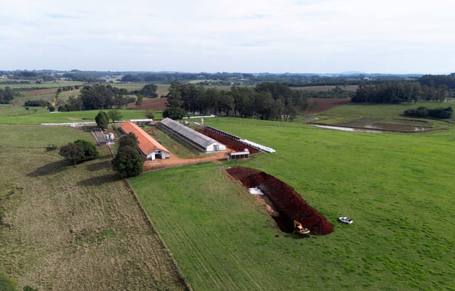 A drone view shows an excavator moving earth next to a hole in the ground at a poultry farm, after Brazil confirmed its first outbreak of bird flu on Friday, triggering protocols for a country-wide trade ban from top buyer China and state-wide restrictions for other major consumers, in Montenegro, Brazil May 17, 2025. REUTERS/Diego Vara/File Photo