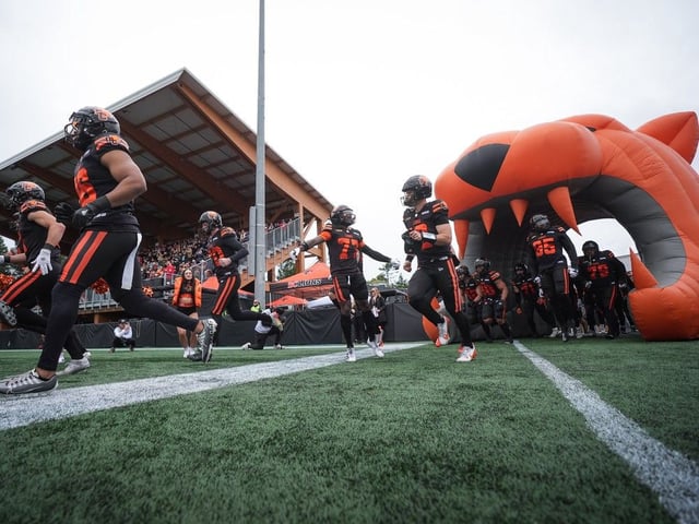  B.C. Lions quarterback Nathan Rourke, front right, Seven McGee, back centre, and the rest of the team run onto the field before a preseason CFL football game against the Calgary Stampeders, in Langford on Monday