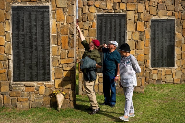 Visitors at the Nampo agricultural fair, one of the largest in the southern hemisphere, check names on the wall of remembrance, a tribute to farmers killed since 1961, near Bothaville, South Africa, May 15, 2025. (AP Photo/Jerome Delay)