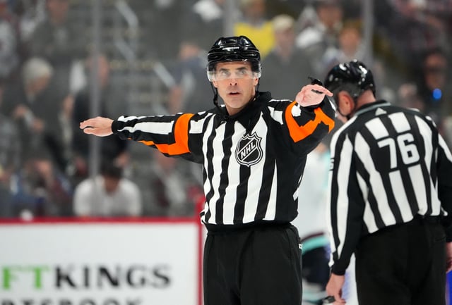Apr 30, 2023; Denver, Colorado, USA; NHL referee Chris Rooney (5) calls a reversal of a goal by Colorado Avalanche center Nathan MacKinnon (29) (not pictured) in the third period against the Seattle Kraken in game seven of the first round of the 2023 Stanley Cup Playoffs at Ball Arena. Mandatory Credit: Ron Chenoy-USA TODAY Sports