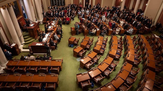 Democratic House seats remain empty in protest as Republican House members stand as they are sworn in at the beginning of the first day of the 2025 Legislature at the State Capitol in St. Paul, Minnesota, on Jan. 14, 2025. (Renée Jones Schneider/The Minnesota Star Tribune/TNS)
