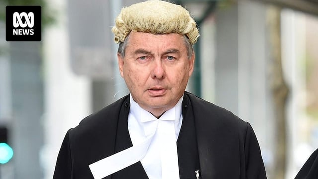 Walter Sofronoff dressed in court robes walks down a street. in Brisbane