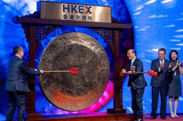Robin Zeng, founder and chairman of Contemporary Amperex Technology Co. Ltd. (CATL), third right, strikes a gong as Paul Chan, Hong Kong's financial secretary, second right, and Bonnie Chan, chief executive officer of Hong Kong Exchanges & Clearing Ltd. (HKEX), right, applaud during the CATL listing ceremony at the Hong Kong Stock Exchange in Hong Kong, China, on Tuesday, May 20, 2025.