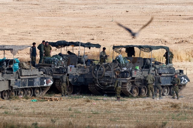Israeli soldiers stand next to military vehicles, near the border with Gaza, in Israel, May 20, 2025. REUTERS/Amir Cohen