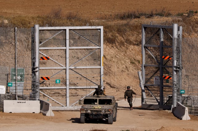 An Israeli soldier closes a gate at the border fence with Gaza, as seen from Israel, May 20, 2025. REUTERS/Amir Cohen     TPX IMAGES OF THE DAY