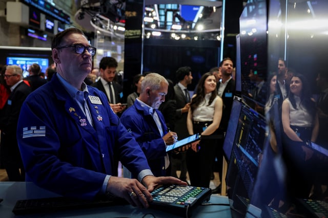 Traders work on the floor at the New York Stock Exchange (NYSE) in New York City, U.S., May 19, 2025. REUTERS/Jeenah Moon/File Photo