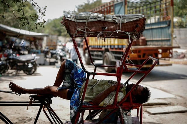 A man sleeps in his rickshaw during a heatwave on a hot summer day in New Delhi, India, June 18, 2024. REUTERS/Adnan Abidi/File Photo