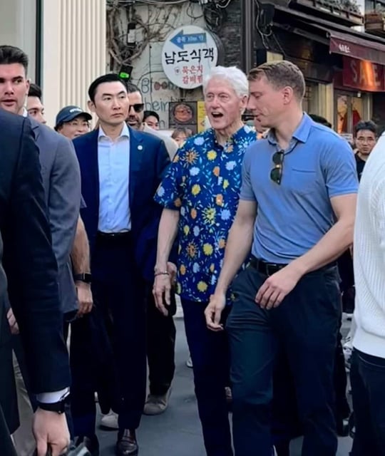 This photo provided Yonhap News reader Kim Ye-rim shows former U.S. President Bill Clinton (C) in central Seoul. (PHOTO NOT FOR SALE) (Yonhap)