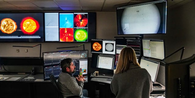 Forecasters monitor satellite feeds and other data at the federal Space Weather Prediction Center in Boulder, Colorado, in May 2024.