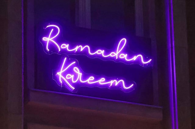 Elektrisch beleuchteter Schriftzug „Ramadan Kareem“ in lila Neonbuchstaben, angebracht am Rathaus Tiergarten in Berlin-Mitte, Mathilde-Jacob-Platz. Der Schriftzug – deutsch: „großzügiger Ramadan“ – wurde erstmals in Berlin zum Beginn des islamischen Fastenmonats installiert. Das Rathaus Tiergarten wünschte bereits „Ramadan Kareem“: Grüne wollen diese Festtagsbeleuchtung in ganz Berlin. Foto: IMAGO / Berlinfoto