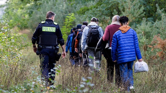Ein Bundespolizist mit aufgegriffenen Migranten