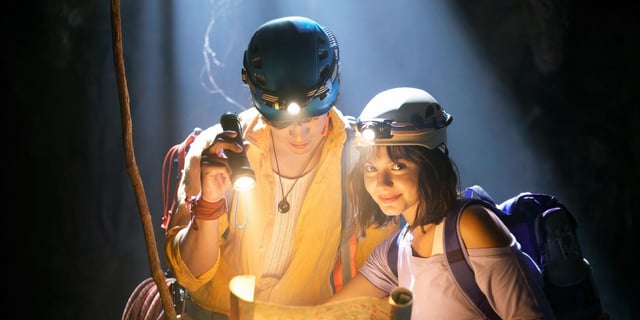 Samantha Lorraine and Jacob Rodriguez examine a map in a cave in Dora and the Search for Sol Dorado