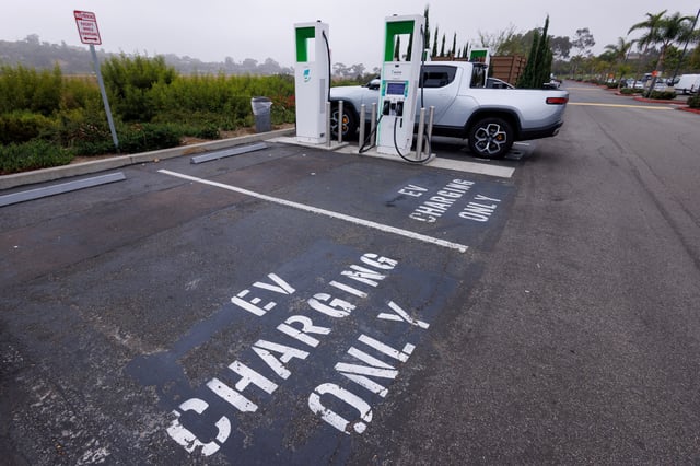 Electric vehicle chargers from Electrify America are shown in a shopping center parking lot in Oceanside, California, U.S.,October 19, 2023.     REUTERS/Mike Blake/File Photo