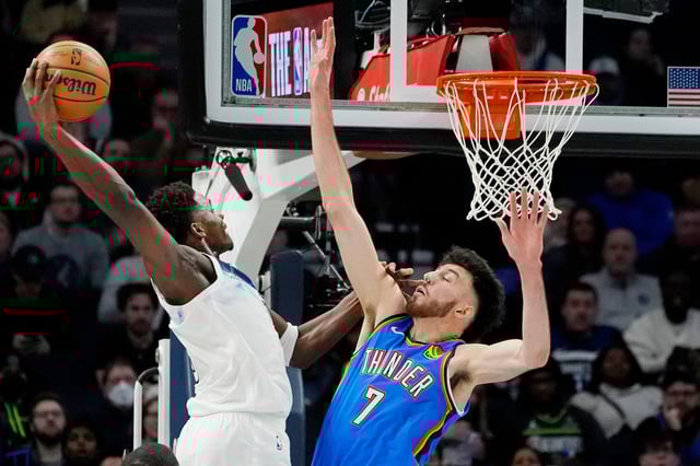 Timberwolves guard Anthony Edwards goes airborne for a dunk as Thunder center Chet Holmgren tries to defend during their Feb 13, 2025, game in Minneapolis.