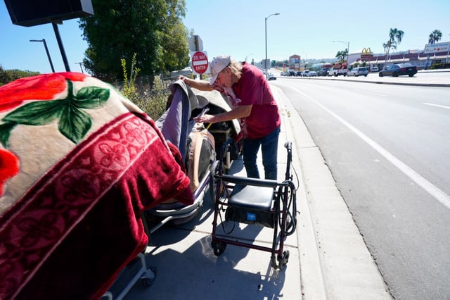Spike Gibson, 69, a retired construction worker, looks through his personal belongings in a shopping cart near the parking lot off Jamacha Blvd. in Spring Valley, CA. Gibson says he is living on the streets in the nearby area however, in the past he has slept in the empty parking lot.  (Nelvin C. Cepeda / The San Diego Union-Tribune)