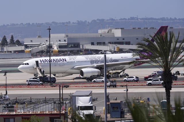 A Hawaiian Airlines airplane sits on the tarmac after an evacuation Tuesday, May 20, 2025, at the San Diego International Airport in San Diego. (AP Photo/Gregory Bull)