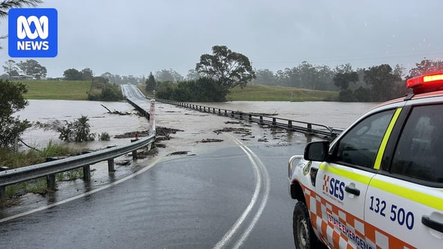 An SES truck comes to a halt ahead of a flooded bridge on the NSW Mid-North Coast. 