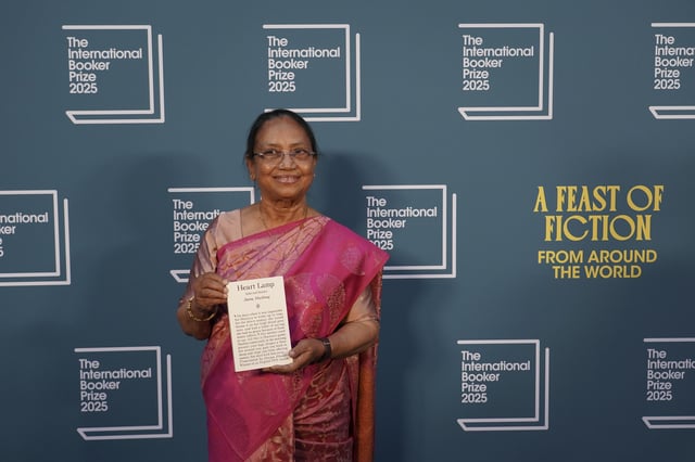 Banu Mushtaq, author of 'Heart Lamp' holds her book as she poses for photographers upon arrival for the International Booker Prize, in London, Tuesday, May 20, 2025.(AP Photo/Alberto Pezzali)