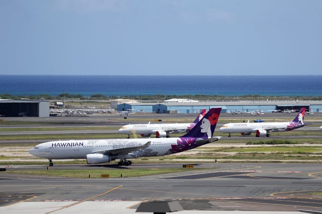 Hawaiian Airlines airplanes sit idle on the runway at the Daniel K. Inouye International Airport.