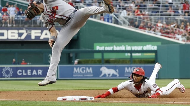 Washington’s CJ Abrams slides into third base after an errant throw gets past Atlanta’s Austin Riley during Tuesday’s game. The Nationals pulled out a 5-3 victory for their fourth straight win.