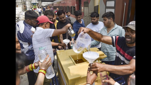 Volunteers distribute water to train passengers on a hot summer day in Jalandhar on Tuesday. (PTI)